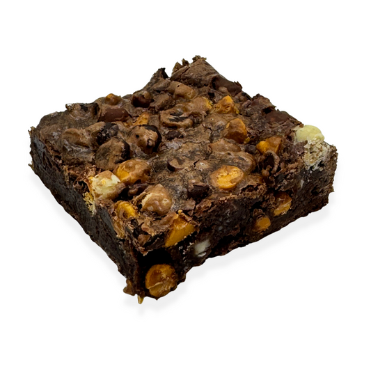 A single gluten-free brownie with butterscotch, white, milk, dark and semi-sweet chocolate chips on a white background.