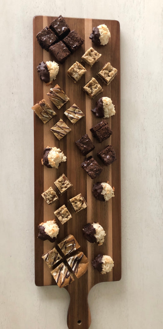 A board filled with bar bites including brownies, oatmeal caramelitas, cookie bars, and coconut macaroons