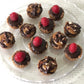A platter with 12 individual pecan tarts; turtle pecan and raspberry pecan tarts