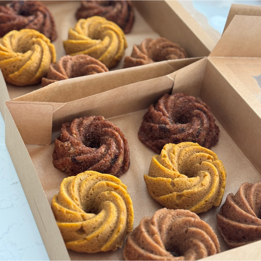 Variety mini bundt cakes arranged for events, sold by the dozen; pumpkin, carrot cake and banana in boxed gifts.