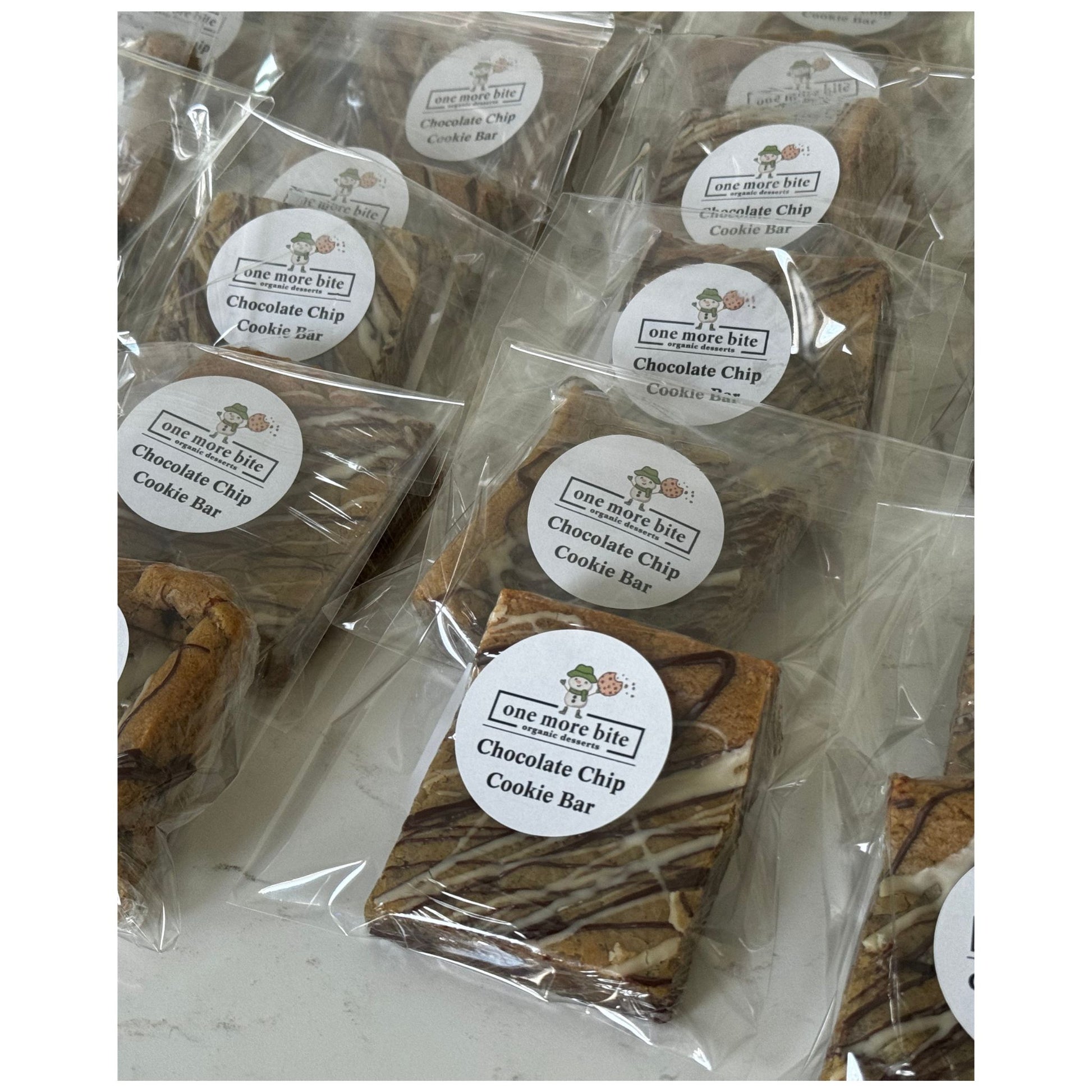 Packaged chocolate chip cookie bars with One More Bite Organic Desserts  branding on a white background. Organic peanut-free chocolate chip cookie bar party pack – soy-free, corn-free dessert handmade in Fort Myers, Florida.