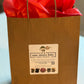 A sample of a kraft handle gift bag with white One More Bite Organic label and red tissue paper